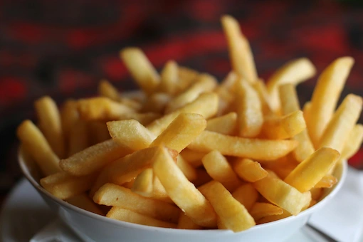 A comforting white bowl topped with fresh, golden straight cut french fries