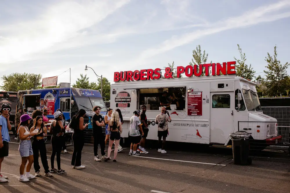 A Burger and Poutine food truck serving a queue of customers